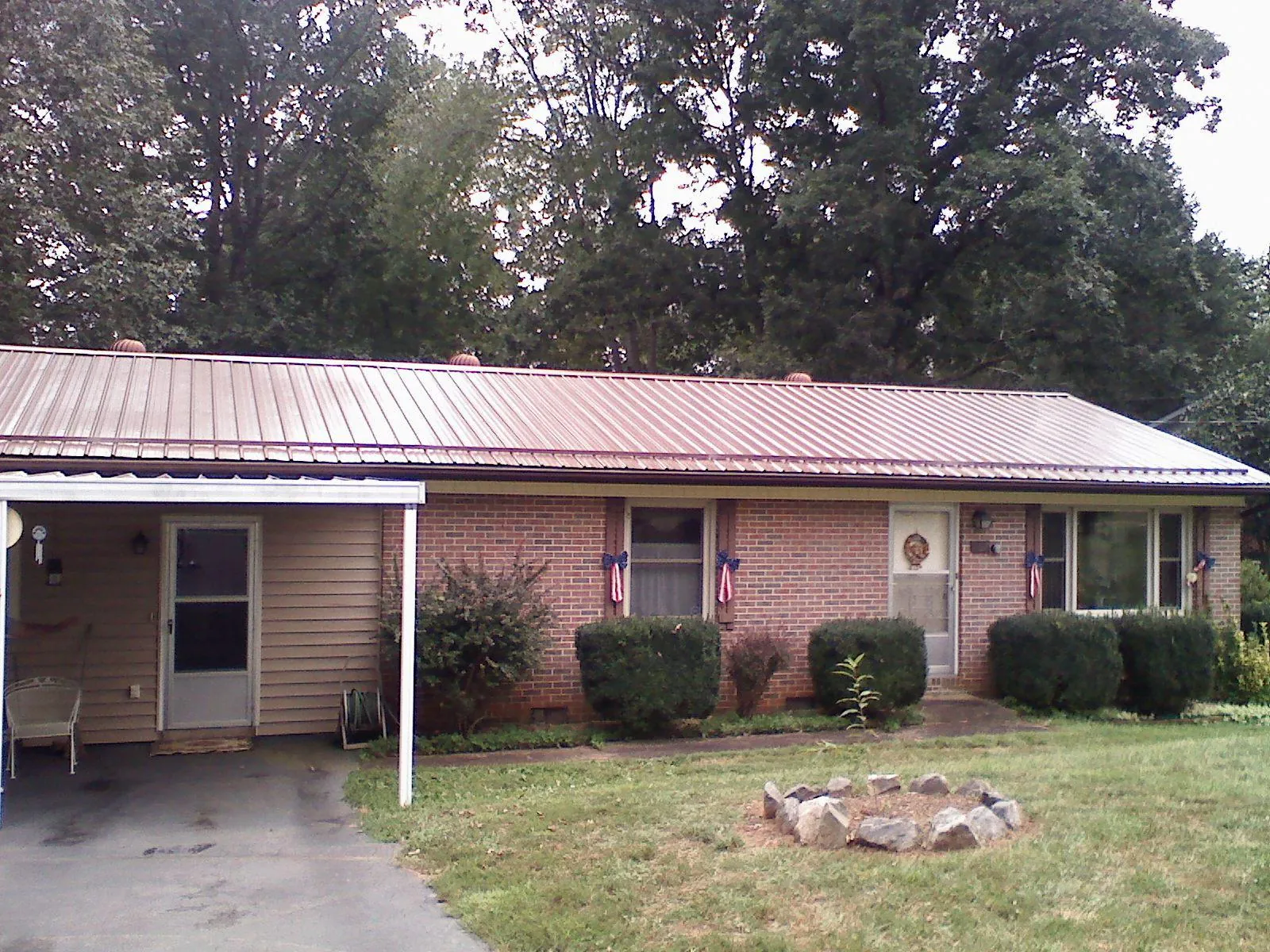 Bronze metal roof and carport on a brick ranch home — Roof Repair work by our crew in Herman